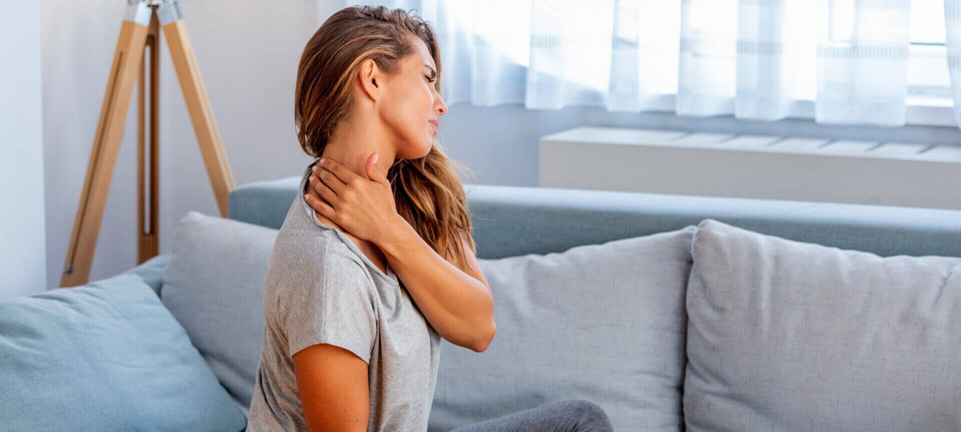 Pain In The Shoulder. Upper Arm Pain, People With Body Muscles Problem, Healthcare And Medicine Concept. Attractive Woman Sitting On The Bed And Holding Painful Shoulder With Another Hand.